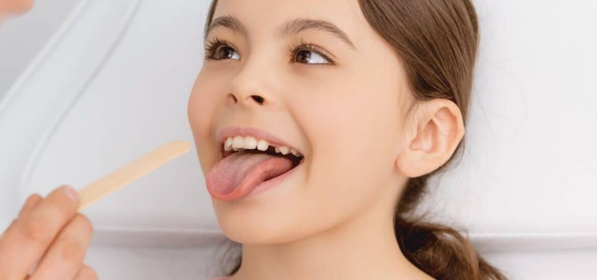 Kid girl getting checked by dentist