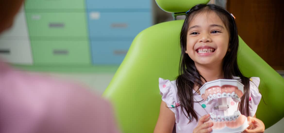 Smiling child learning about dental care during a family dental visit at a Family Dentist in Salt Lake City.